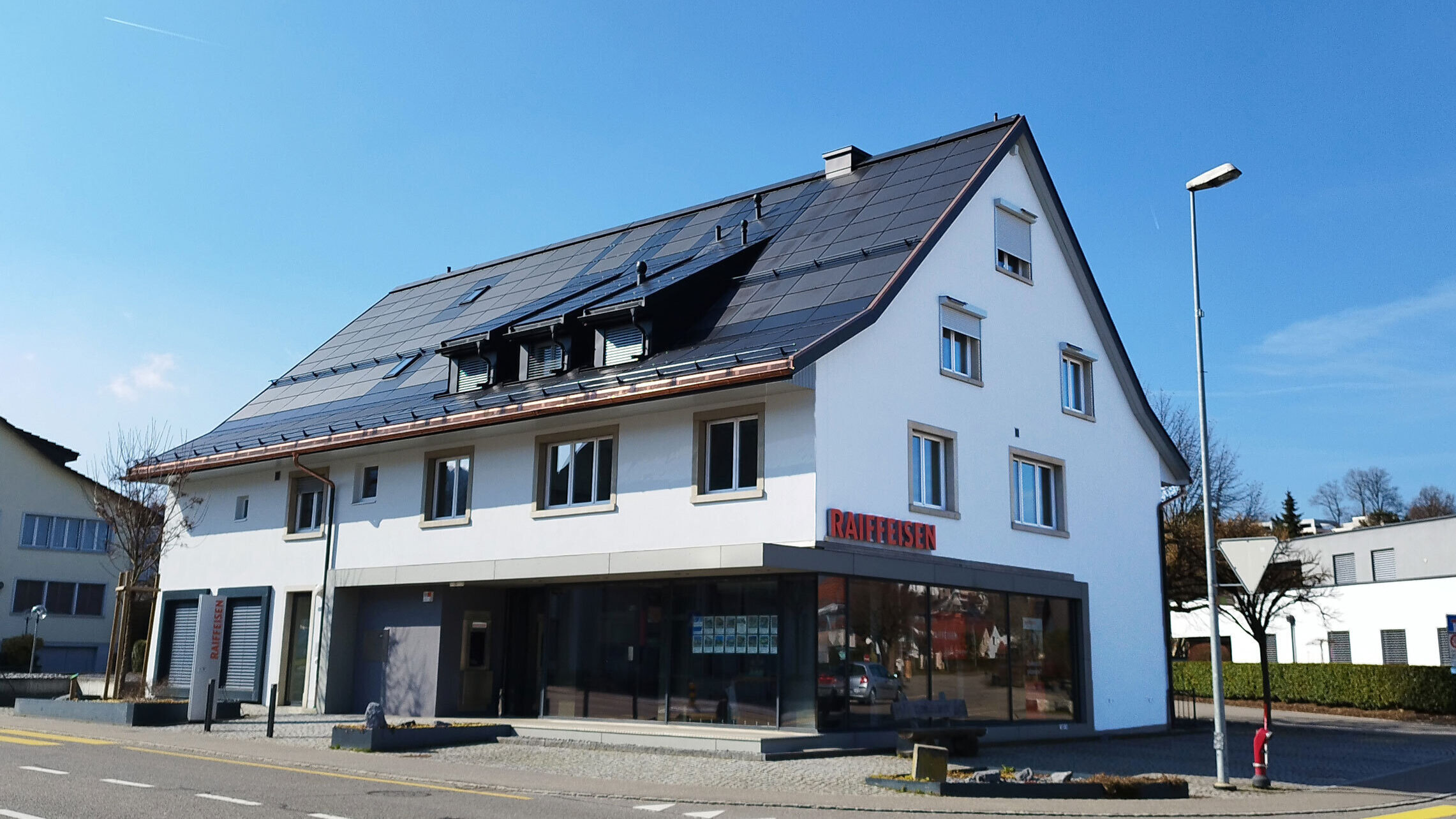 Aussenansicht der Raiffeisenbank in Gipf-Oberfrick bei Sonnenschein.